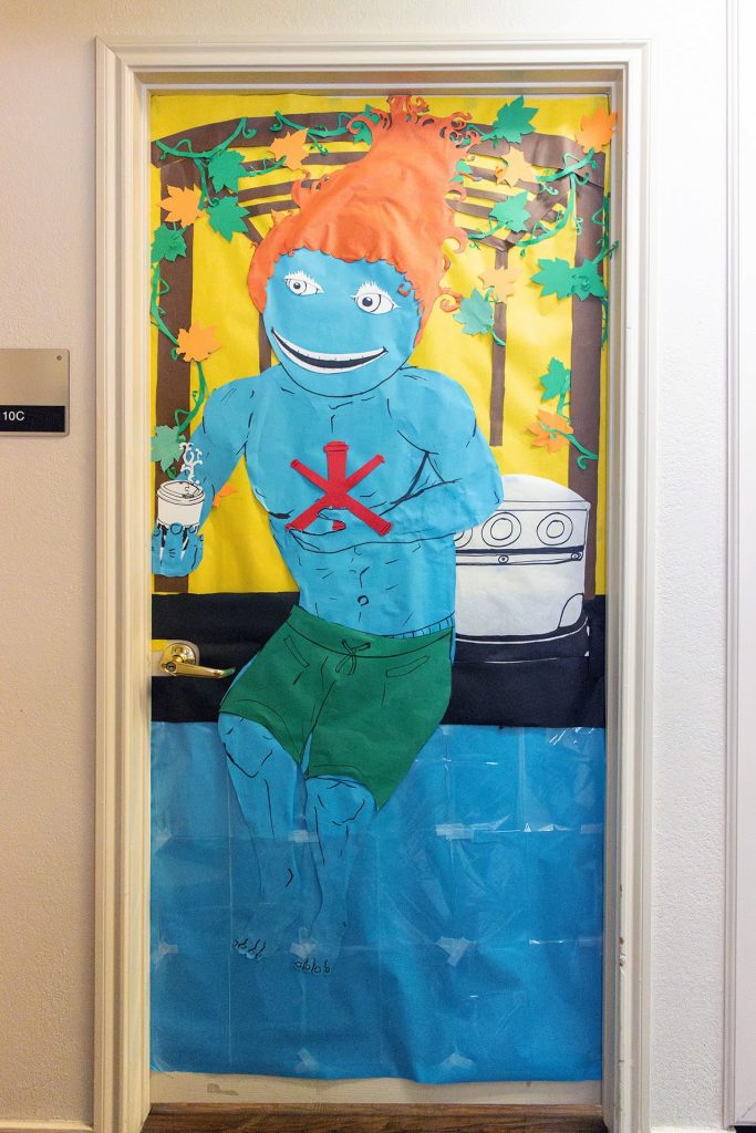 Homecoming Door Decoration; A shirtless Temoc dips his feet in a pool - Phase 8 Clubhouse